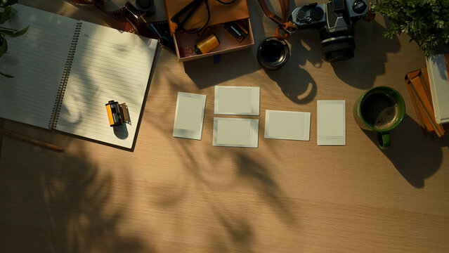 Creative workspace with vintage camera, notebook, and coffee cup in warm morning sunlight