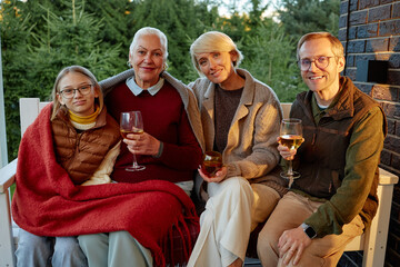 Caucasian senior woman, middle aged woman, middle aged man, and teen girl sitting together...