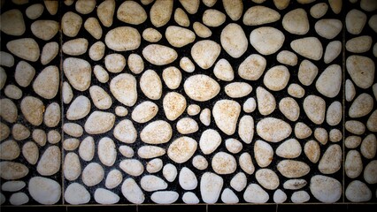 A textured wall surface made of smooth, light-colored pebbles set in dark grout.