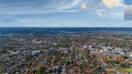 Fototapeta premium Panorama Sunset aerial drone view of western Sydney Suburbs of Canterbury Burwood Ashfield Marrickville Campsie with Houses roads and parks in Sydney New South Wales NSW Australia