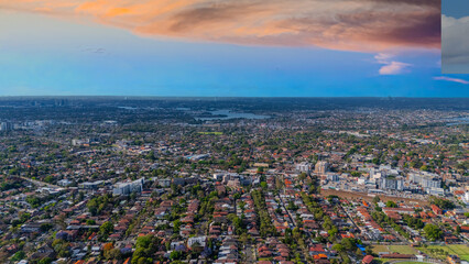 Panorama Sunset  aerial drone view of western Sydney Suburbs of Canterbury Burwood Ashfield Marrickville Campsie with Houses roads and parks in Sydney New South Wales NSW Australia