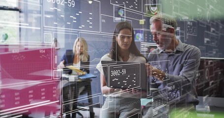 Analyzing colleagues in business attire reviewing data charts on laptop in open-plan office