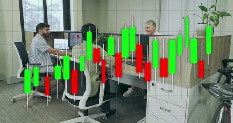 Collaborating office workers analyzing candlestick charts at open-plan L-shaped desks with monitors