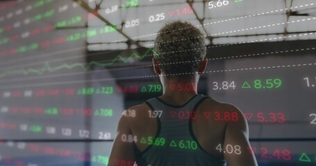 Shadowboxing female athlete wearing sports tank facing away in boxing ring with market data overlay