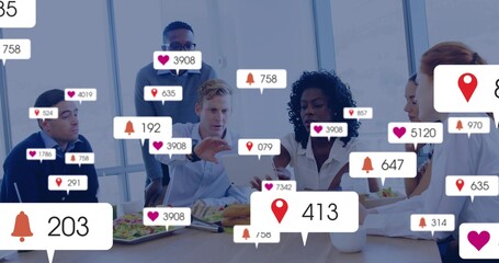 Coworkers collaborating in conference room, with tablet, salads, coffee mugs and notification icons