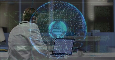 Displaying mid-adult man examining holographic globe while working on laptop at office, copy space
