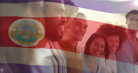Standing six smiling friends wearing clothes outdoors at sunset, with Costa Rica flag crest overlay