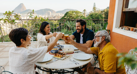 Family toasting to a barbeque meal on a balcony in Rio