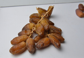 Branch of Tunisian Deglet Nour Dates on White Background