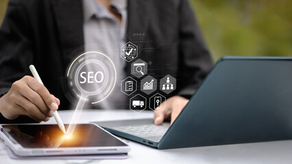 Business Professional Using Tablet with Stylus and Laptop Showing SEO Interface