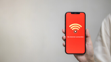 Hand Holding Smartphone Showing No Internet Connection Alert on Red Screen
