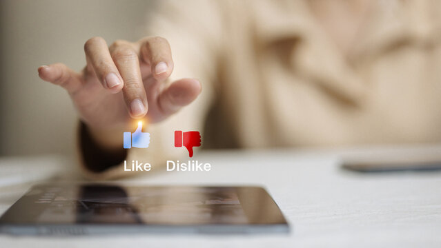 Hand Choosing Like or Dislike Icons Above Tablet, Social Media Feedback