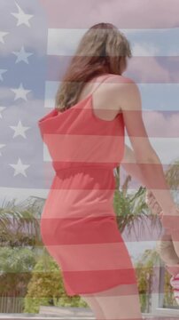 Animation of american flag over happy caucasian mother and son dancing by sunny pool