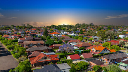Fototapeta premium Panorama Sunset aerial drone view of western Sydney Suburbs of Canterbury Burwood Ashfield Marrickville Campsie with Houses roads and parks in Sydney New South Wales NSW Australia