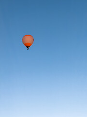 A hot air balloon flies over the city Yerevan, background of the blue sky. Aerial view of many colorful hot air balloons fly in the sky. High quality