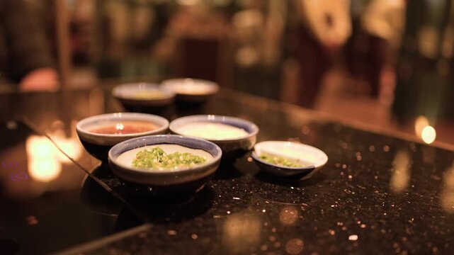 Hand Reaching for Asian Sauces on Restaurant Table