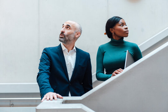 Thoughtful businessman and businesswoman on staircase
