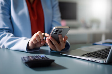 Woman counting coins on calculator taking from the piggy bank. hand holding pen working on calculator to calculate on desk