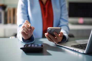 Businesswoman using a stylus with smart phone in office. Concept of smart technology, remote work