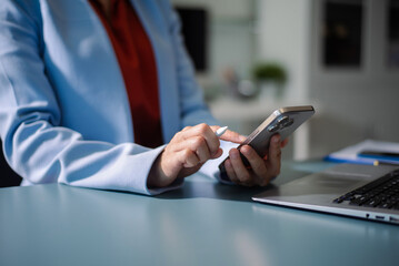 Businesswoman using a stylus with smart phone in office. Concept of smart technology, remote work