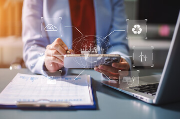 Woman using futuristic interface with smart tech and mobile to manage ESG, clean energy, and sustainability data.