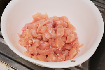 Raw sliced chicken meat on the bowl