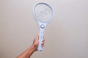 Person hand holding electric mosquito racket