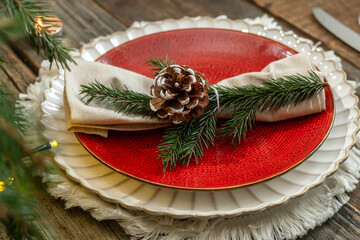 Festive Christmas table decor. Plates and napkin decorated pine cone and spruce twig.