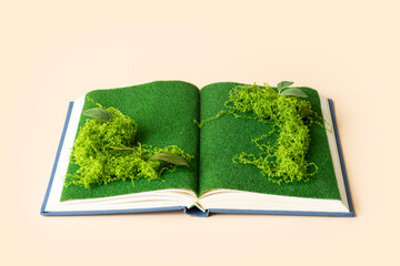 Open page with with plants and moss growing. Plain background. Conceptual sustainable lifestyle still life. 

