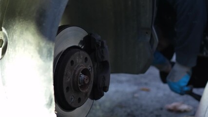 The master unscrews the bolt with a screwdriver and removes the protective plastic (mudguard) behind the car wheel to replace the fuel filter. home self-repair of the car