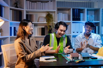 Architects and engineers work together in an office to review blueprints, exchange ideas, and refine their building plans for a contemporary construction project in an urban setting.