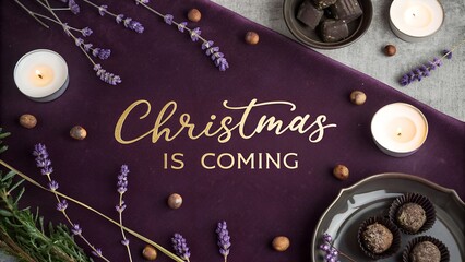Festive overhead flat lay with "christmas is coming" text on deep plum velvet