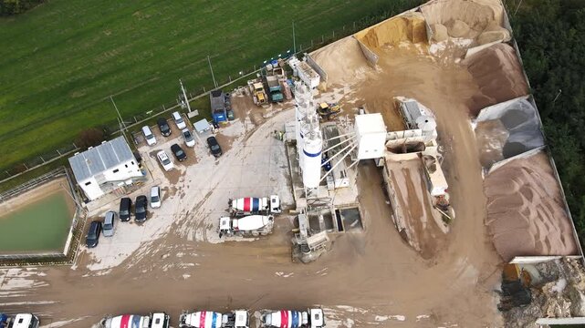 Concrete plant with silos, mixer trucks and raw material storage. Cement factory, aerial view. Production and delivering concrete and building materials