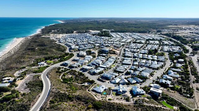 Aerial view of houses with white roofs near the beach, contrasting sharply with the turquoise water, Lancelin, Western Australia, Australia.