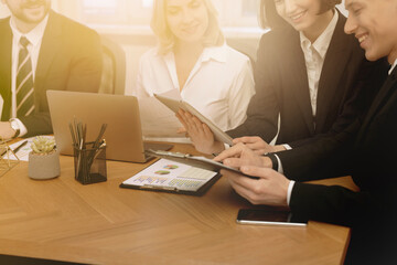 Coworkers working together at table in office