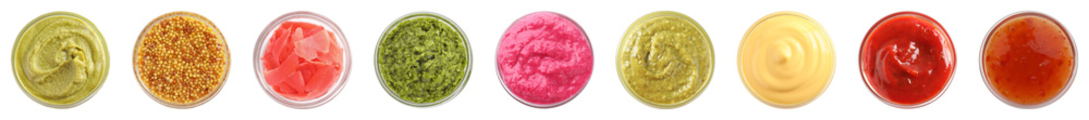 Various condiments in bowls isolated on white, set. Top view