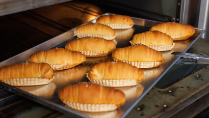 Freshly baked salted butter roll bread on baking tray inside oven, Golden brown texture homemade bakery concept, warm and delicious pastry background, ready to serve buns in small local bakery kitchen