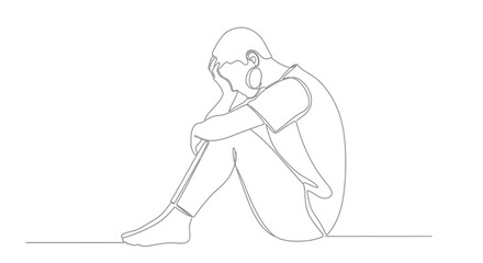 A person sits alone with their head in their hands in a moment of distress.