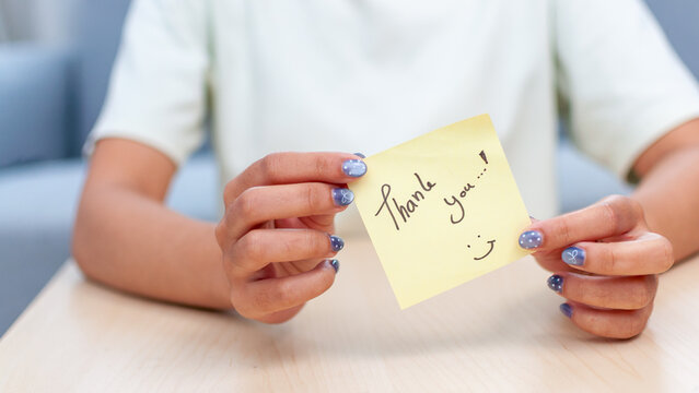 Gratitude gesture thank you note home office bright atmosphere close-up appreciation