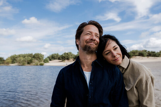 Couple embracing outdoors by the sea on a windy day