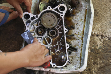 Focused mechanic hand performing engine repair and maintenance service in workshop. Close up detail...