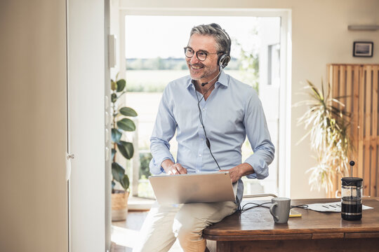 Smiling customer care representative with laptop at home office