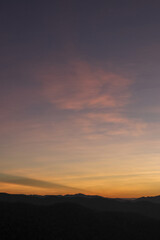 Fototapeta premium Peaceful and calm twilight sky with colorful gradient over dark mountain silhouette. serene atmosphere at dusk or dawn offers beautiful and tranquil background