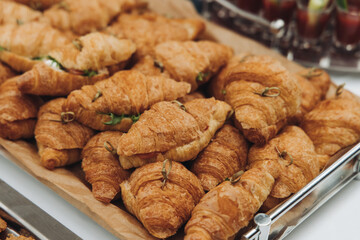Set of coffee break in the hotel during conference meeting, with tea and coffee catering, decorated catering banquet table with variety of different pastry and bakery, with croissants, pie and cookies