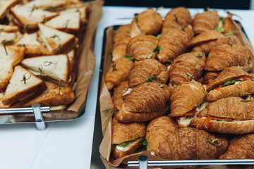 Set of coffee break in the hotel during conference meeting, with tea and coffee catering, decorated catering banquet table with variety of different pastry and bakery, with croissants, pie and cookies