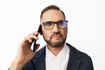 A professional man speaks on a mobile phone, set against an isolated color background. The scene...