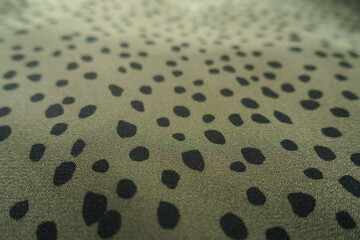 Close view of olive green and black spotted fabric