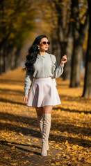 Stylish Woman Walking in an Autumn Park