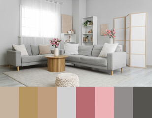 Obraz premium Cozy sofas and magnolia flowers in vase on coffee table in room