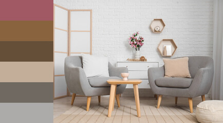 Armchairs, coffee table and chest of drawers with magnolia flowers in room